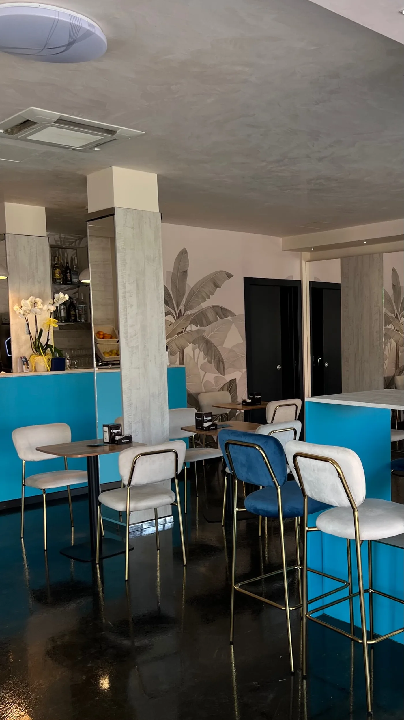 Bancone bar turchese di Capolaterra Cafè con sgabelli velluto